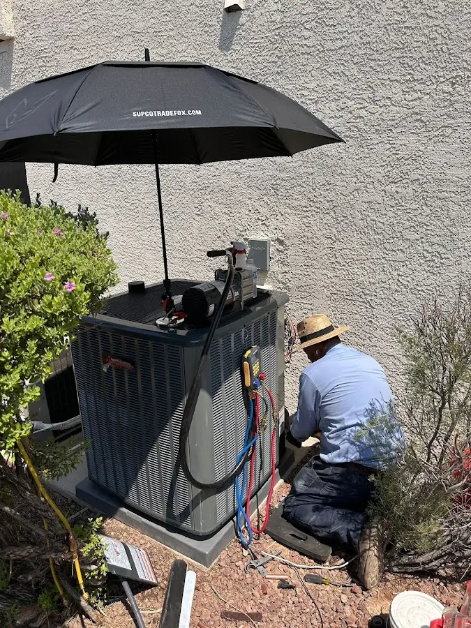 HVAC technician performing outdoor AC maintenance in Terrell Hills