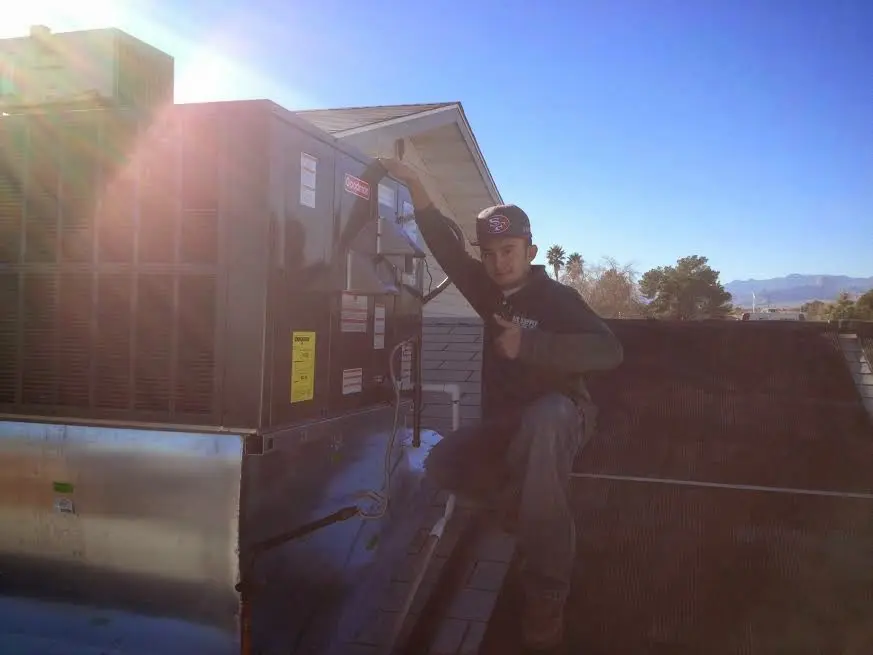 HVAC technician performing Air Duct Repair on a rooftop unit in Terrell Hills